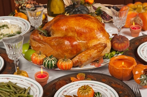 A delicious Thanksgiving dinner is displayed proudly on a dining room table.