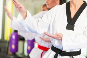 A black and red belt practice a form during martial arts class.