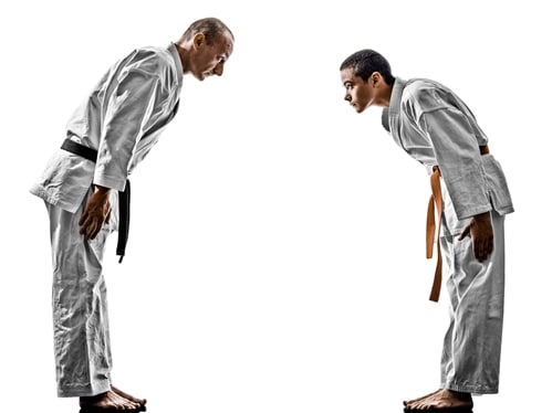A young martial artist bows to his instructor as a sign of respect.