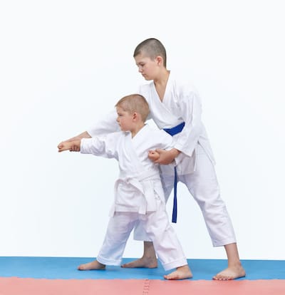 Brother with a blue belt teaches the brother with a white belt martial arts.