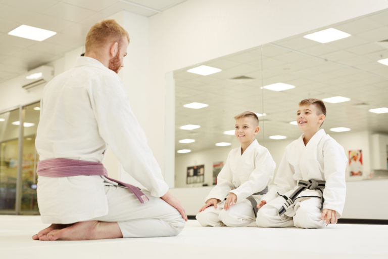 martial arts coach training two young students
