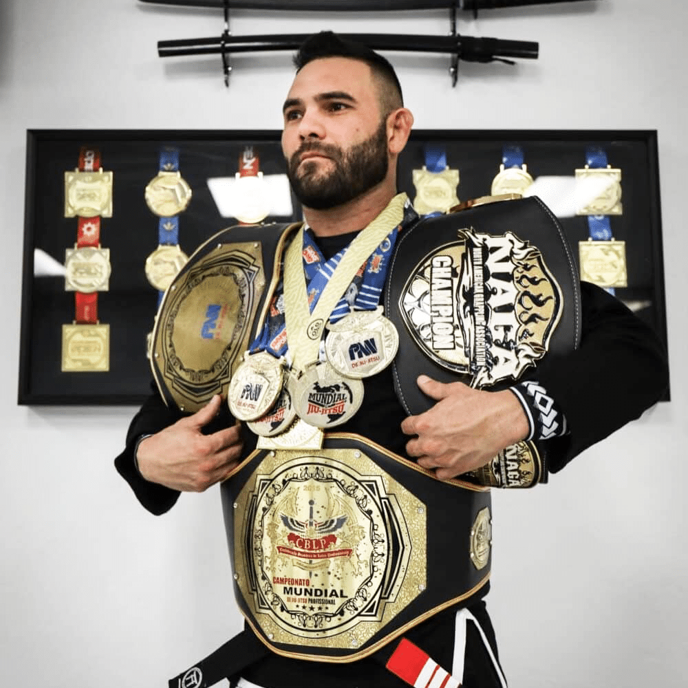 Man draped in multiple championship medals and belts